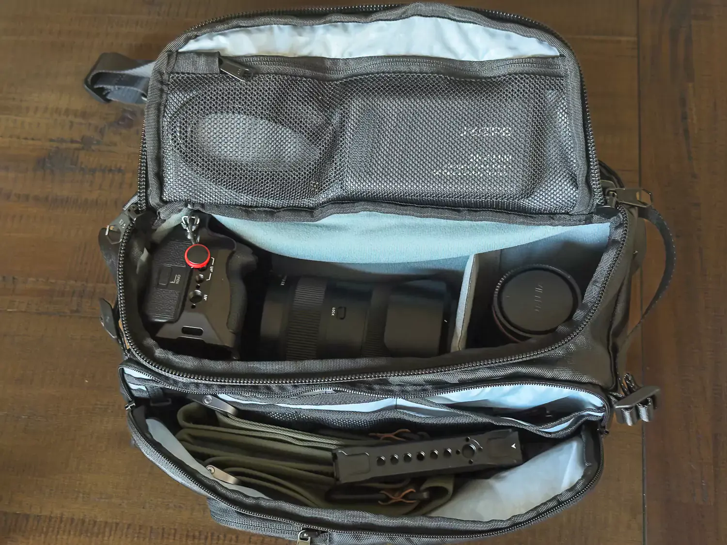 Interior view of the Hex Ranger Sling Camera Bag packed with a camera body, lenses, and accessories, highlighting its storage capacity.