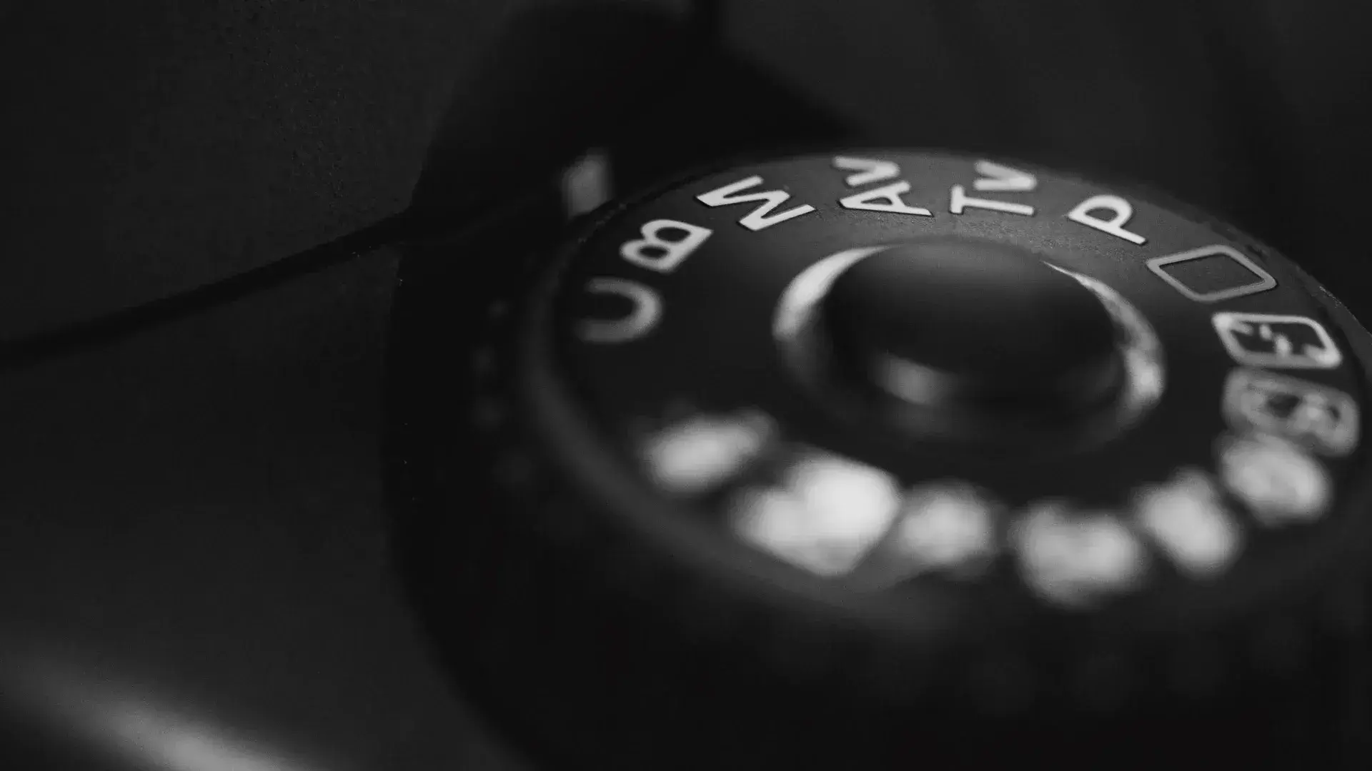 Close-up of a camera mode dial showing Manual (M), Aperture Priority (Av), Shutter Priority (Tv), and Program (P) modes, illustrating camera settings for photography.