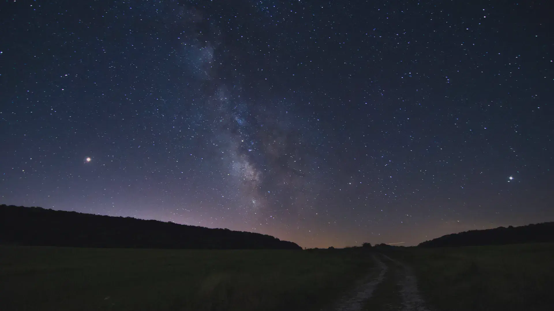 Stunning long exposure photo of the Milky Way in a clear night sky over a rural landscape, showcasing astrophotography techniques